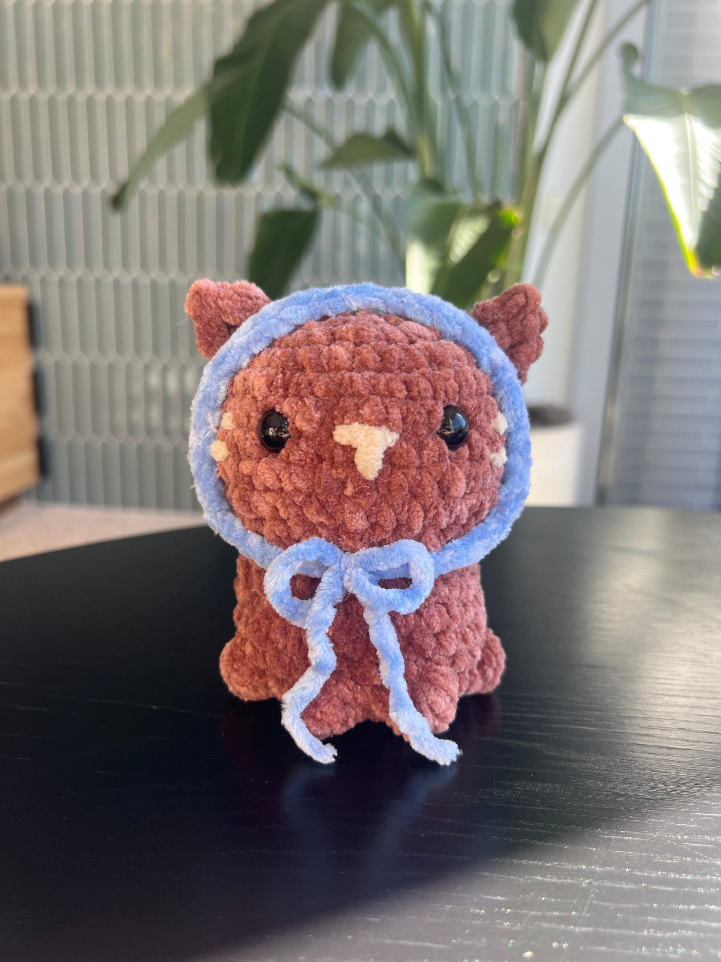 Rust brown crochet cat plushie with blue bonnet